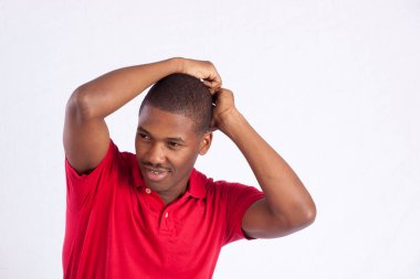 Kırmızı gömlekli mutlu siyah adam. Eli başının üstünde.