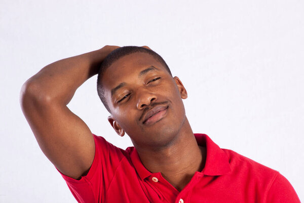 Happy Black man in a red shirt with his hand on his head