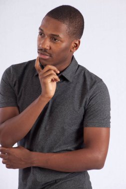 Yakışıklı siyah adam düşünceli görünüyor.
