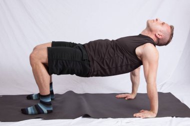 Siyah kıyafetli yakışıklı adam geriniyor.