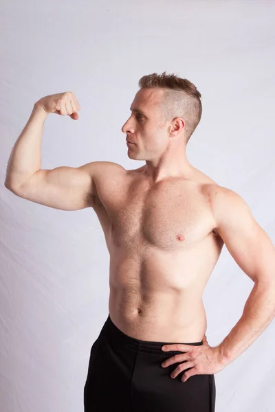 强壮的男人炫耀他的肌肉 — 图库照片