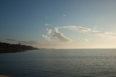 Suyun üzerinde gün batımı dalgalarla