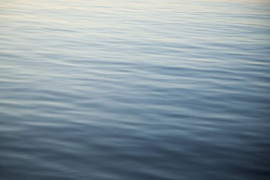 Gün batımını yansıtan dalgalı su soyut.