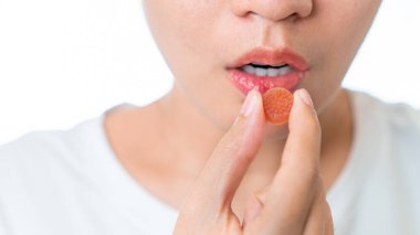 Beyaz arka planda kronik uykusuzluğu tedavi etmek için bağırarak tıbbi melatonin tutan Asyalı kadını yakından çek..