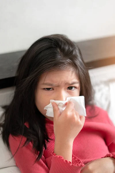 病気のアジアの女の子は ベッドルームでベッドの上で組織に高熱のインフルエンザやくしゃみを持っています ヘルスケアと普及感染症ウイルスの概念を防止します 選択的な焦点 — ストック写真