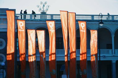 Tatilin şehir manzarası. İnsanlar dinleniyor. Rüzgarda kırmızı bayraklar