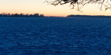 Gün batımında kar tarlasına yakın bir manzara