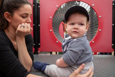 Anne ve bebek çocuk oyun alanında oynuyorlar..
