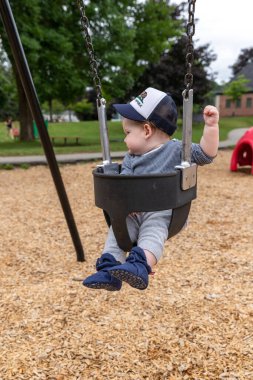 Anne ve bebek çocuk oyun alanında oynuyorlar..