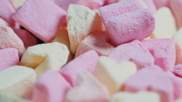 Söt mat bakgrund. Små rosa och gula marshmallows närbild. — Stockvideo