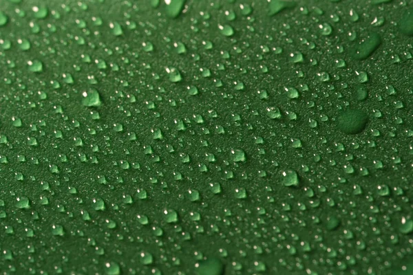 Gotas de agua sobre una superficie verde —  Fotos de Stock