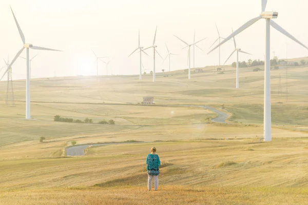 Ветряные турбины в поле и женщина Стоковое Фото