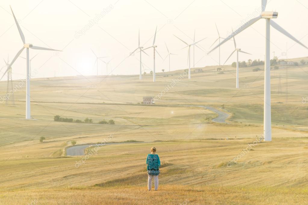 Wind turbines in a field and a woman