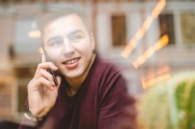 Pencerenin üzerindeki mutlu adam telefonu.