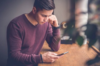 Kafede elinde telefon olan adam.