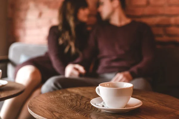 座っているカップルの背景にあるコーヒーのカップ — ストック写真