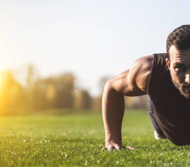 Yakışıklı sporcu çimlere basıyor.