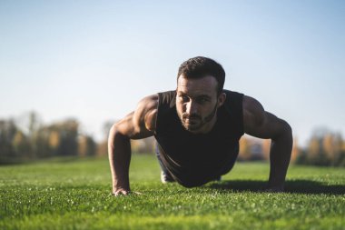 Yakışıklı sporcu çimlere basıyor.