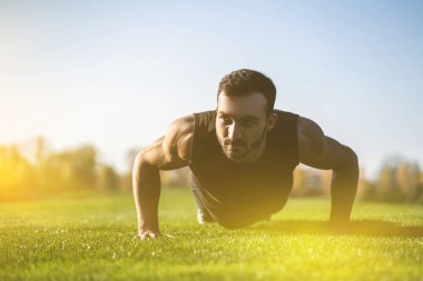 Çimlere basan yakışıklı adam.