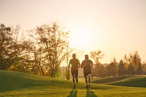 The old and young sportsmen running in the beautiful park