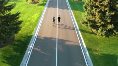 Park yolunda koşan iki adam.