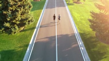 Park yolunda koşan iki adam.