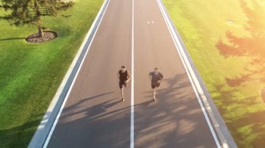 Güzel park yolunda koşan iki adam