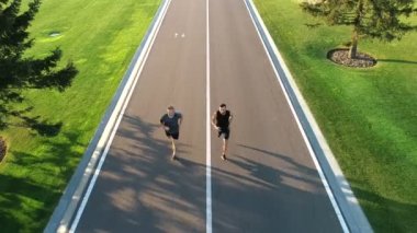 Güzel park yolunda koşan iki adam