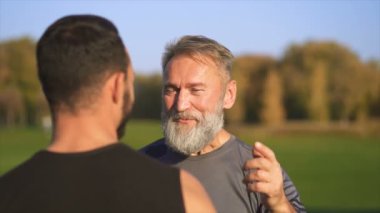 Parkta konuşan mutlu baba ve oğul. yavaş çekim