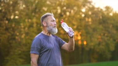 Yaşlı sporcu su içiyor. yavaş çekim