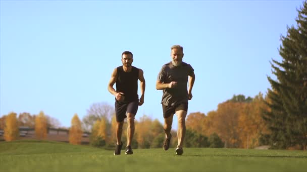 公園を走っている二人の男 スローモーション — ストック動画