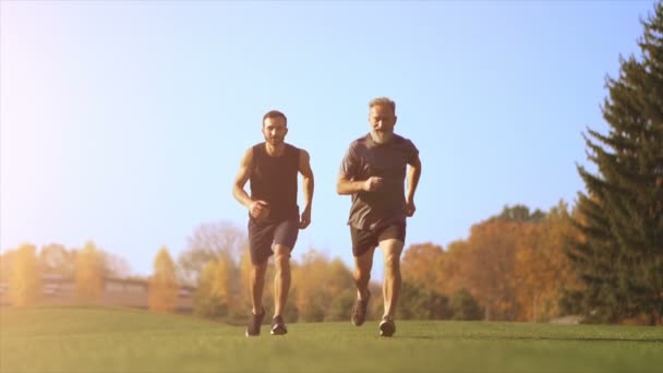 公園を走っている二人の幸せな男 スローモーション — ストック動画