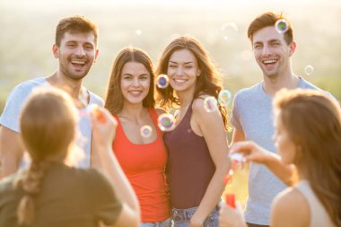 Altı kişi hava kabarcıkları üflüyor.