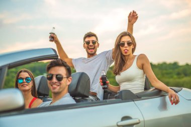 Dört mutlu insan bir Cabrio 'da oturuyor.