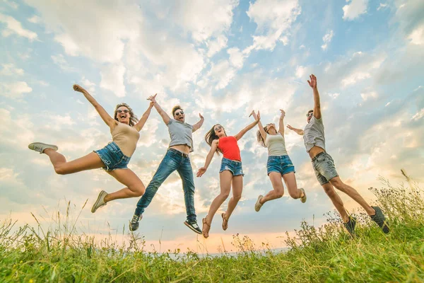 Amigos Felizes Pulando Fundo Das Nuvens — Fotografia de Stock