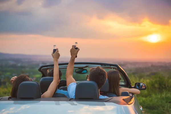 Εταιρεία Των Ανθρώπων Κάθονται Ένα Cabrio Για Φόντο Ηλιοβασίλεμα — Φωτογραφία Αρχείου