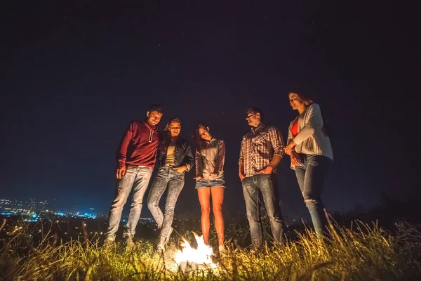 Cinco Pessoas Ficam Perto Fogueira Fundo Cidade Tempo Noturno — Fotografia de Stock