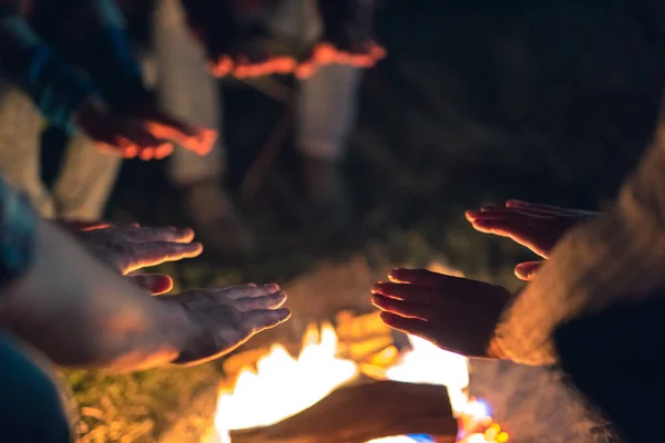 The people warming hands near the bonfire. evening night time