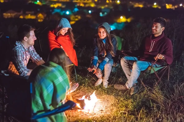 The smile people hold hands near the bonfire. night time