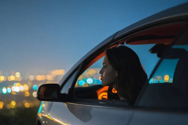 Vrouw Zit Een Auto Achtergrond Van Het Stadslicht Avond Nacht — Stockfoto