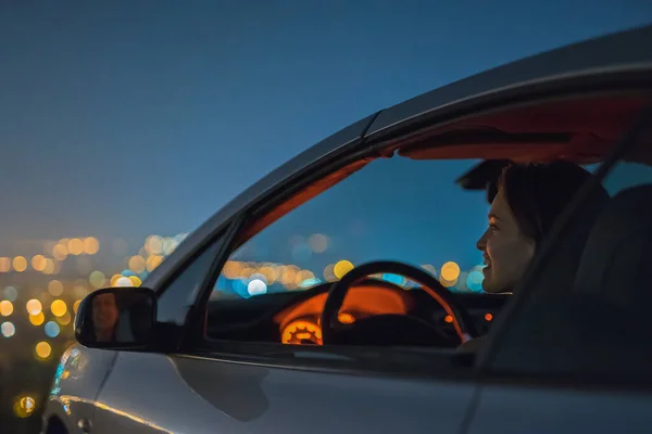 Aantrekkelijke Vrouw Zit Auto Achtergrond Van Stad Nacht Tijd — Stockfoto