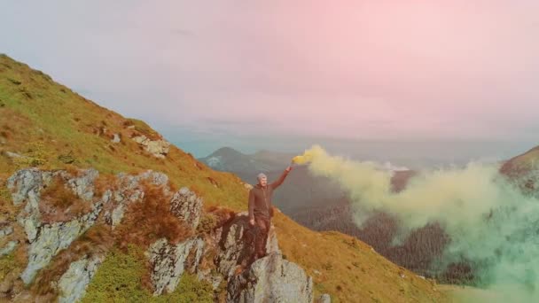 Homem Borda Montanha Com Uma Fumaça Mão Colorida — Vídeo de Stock