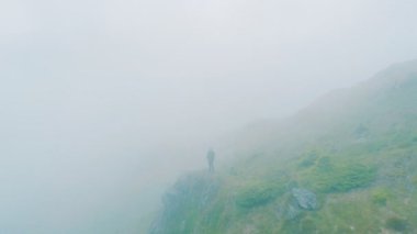 Bir dağın tepesinde duran bir adamın üstündeki uçuş.