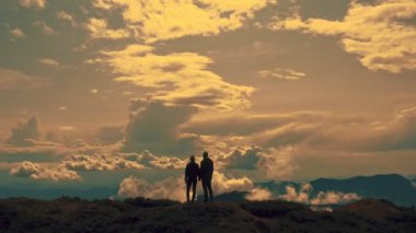 Dağın tepesinde bir kadın ve erkeğin uçuşu.