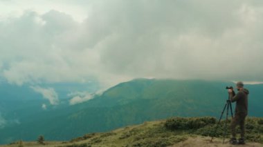 Güzel dağın tepesindeki fotoğrafçının yanındaki uçuş.