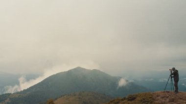 Fotoğrafçı, dağda duran bir kamera.