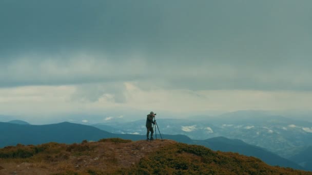 Fotógrafo Com Uma Câmera Topo Montanha — Vídeo de Stock