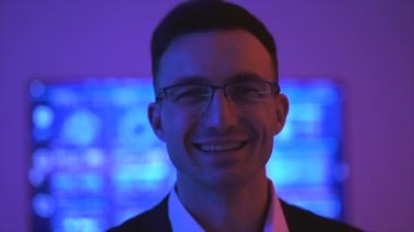 İş adamı karanlık odada gülüyor.