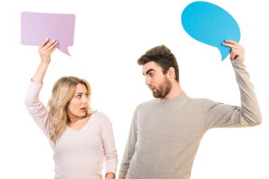 Beyaz arka planda bir diyalog işareti tutan sürpriz çift