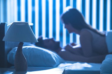 Yataktaki çiftin arka planındaki lamba. Gece vakti.